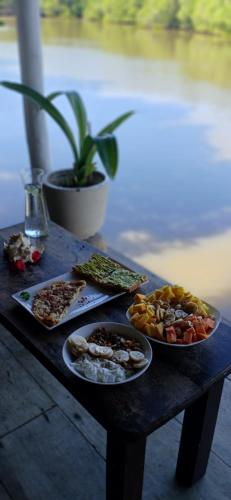 a wooden table with plates of food on it at Ginger Harmony Tangalle Lagoon View in Tangalle