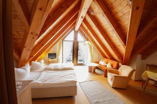 a attic room with a bed and a couch at Gästehaus Merk Merk Gbr in Immenstaad am Bodensee