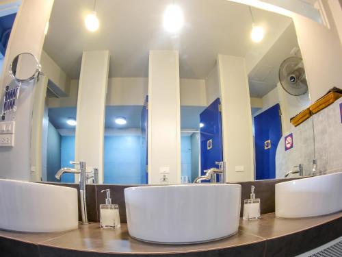 a bathroom with three sinks and a large mirror at The Moon Hostel Huahin in Hua Hin