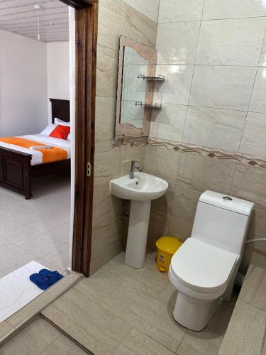 a bathroom with a toilet and a sink and a bed at Rhacky Homes - Near JKIA & SGR in Nairobi