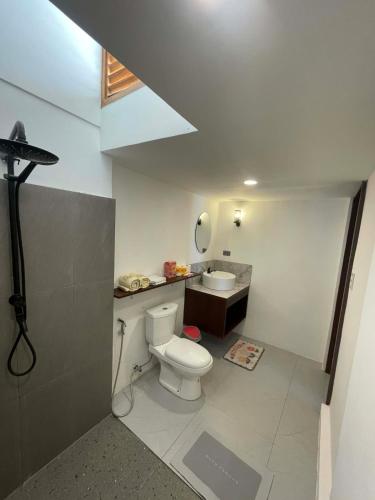 a bathroom with a toilet and a sink at Alfa Beachfront Lofts in El Nido