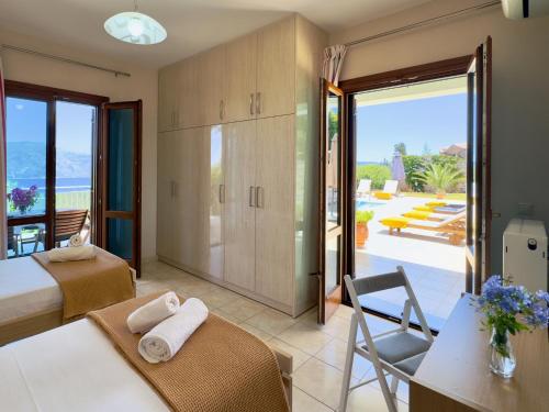 a bedroom with two beds and a view of a patio at Villa Vassilis Fiscardo Kefalonia in Katsaráta