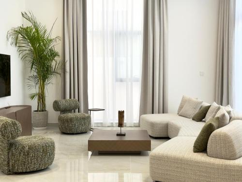 a living room with a couch and chairs and a table at Serenity Stay - Boutique Guesthouse in Abu Dhabi
