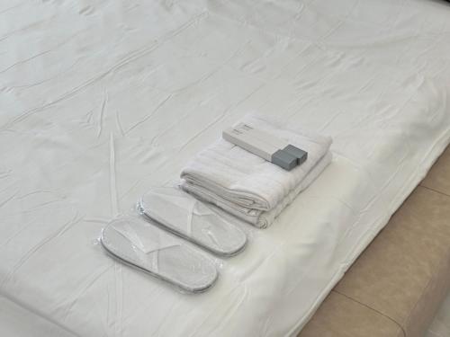 a pair of towels and slippers on a bed at Serenity Stay - Boutique Guesthouse in Abu Dhabi