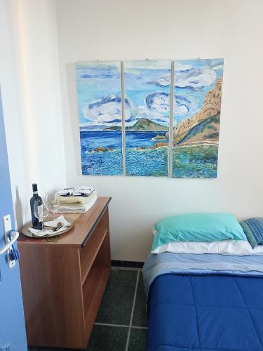 a room with a bed and a desk with two windows at TCEM camera in attico 6 no ascensore in Piombino
