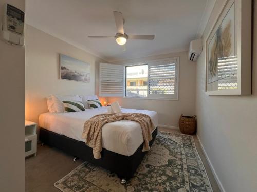 a bedroom with a bed and a ceiling fan at Coastal retreat, private, wine, netflix by Custom Bnb Hosting in Buddina