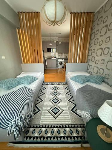 two beds in a room with a kitchen in the background at Tanan Center Serviced Apartments in Ulaanbaatar