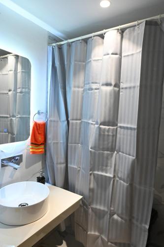 a bathroom with a sink and a shower curtain at Let's Loft - A Premium Luxury Style Duplex Living in Gurgaon