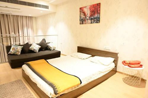 a bedroom with a bed and a couch in it at Let's Loft - A Premium Luxury Style Duplex Living in Gurgaon