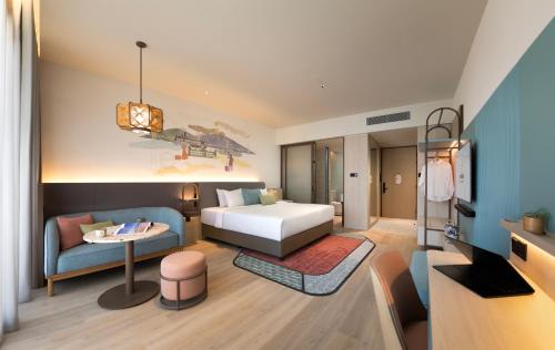 a hotel room with a bed and a couch at Capri by Fraser, Penang in George Town
