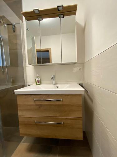 a bathroom with a sink and a mirror at Haus Caré in Weissensee