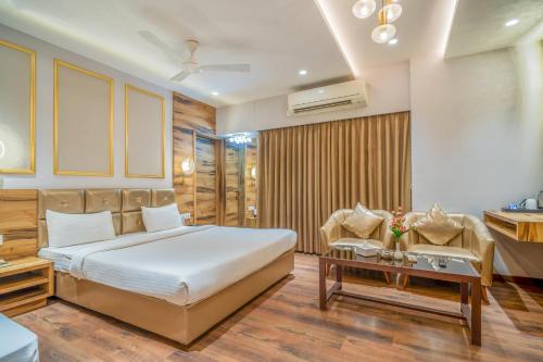 a bedroom with a bed and a living room at Hotel Varun in Guna