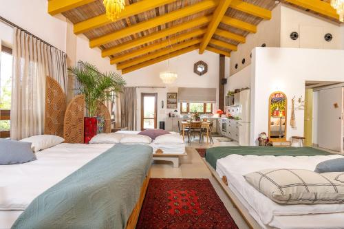 a bedroom with four beds and a dining room at אזמרה בית אירוח מיוחד עם נוף מדהים ובריכה מחוממת בישוב אמירים in Amirim