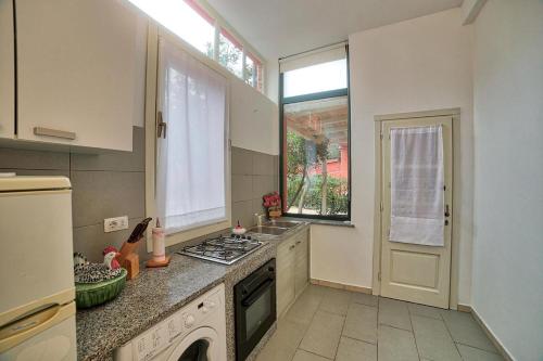 a kitchen with a stove top oven next to a window at Orange Home in Olbia