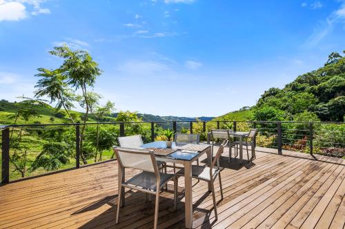 a wooden deck with chairs and a table on it at Top Of The Hill in Maleny
