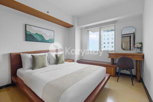 a bedroom with a bed and a desk and a window at Tanea by Kozystay - Braga in Bandung
