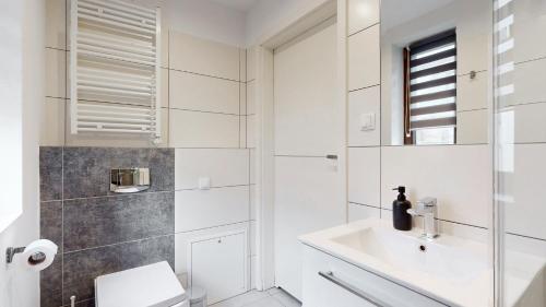 a white bathroom with a sink and a toilet at Studio Fibra Metrio in Rybnik