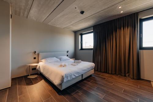 a bedroom with a bed and two windows at Coliving - Bord de Meuse - L'écrin Vert in Oupeye