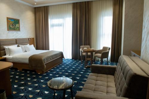 ein Hotelzimmer mit einem Bett und einer Couch in der Unterkunft Aivazovsky Congress Hotel & Spa in Gjumri