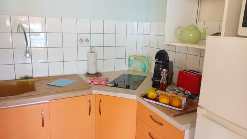 a kitchen with orange cabinets and a sink at Gite Oiseau du Paradis in Le Marin