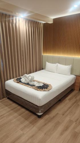 a bedroom with a bed with a blanket and curtains at SVJ Hotel in Cebu City