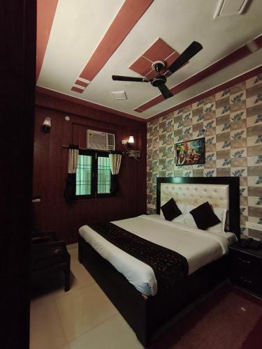 a bedroom with a bed with a ceiling fan at Hotel Jalsa in Haridwār