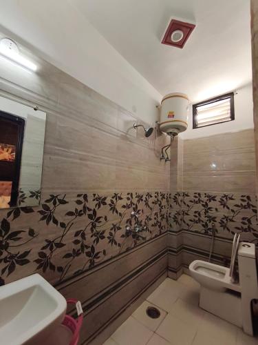 a bathroom with a toilet and a sink at Hotel Jalsa in Haridwār