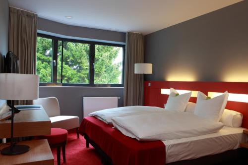 a bedroom with a large bed and a window at The Seven Hotel in Esch-sur-Alzette