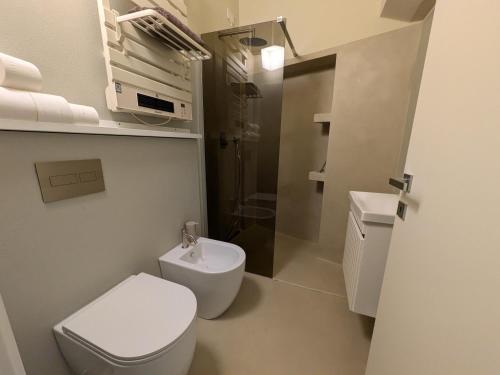 a white bathroom with a toilet and a sink at Fp Monza Railways in Monza