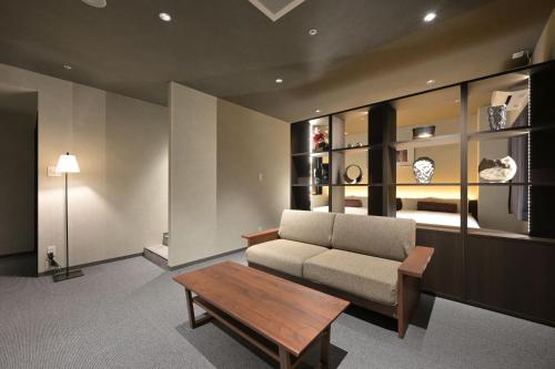 a living room with a couch and a coffee table at HOTEL THE7 Kumamoto in Kumamoto