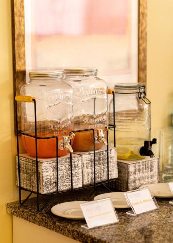 two glass jars on a shelf with a mirror at Almar Aparthotel in Lobito