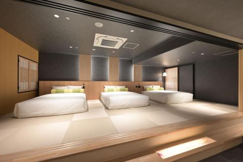 two beds in a large room with at HOTEL THE7 Kumamoto in Kumamoto