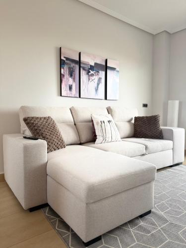 a white living room with a white couch at SunGolf Apartment in Los Alcázares