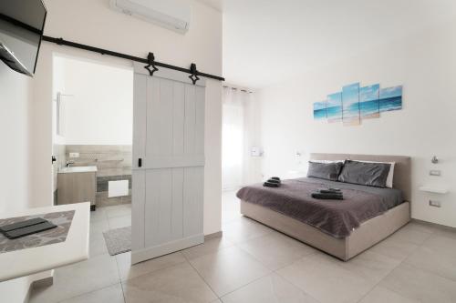 a bedroom with a bed and a sliding glass door at B&B a due passi dal centro in Castelsardo