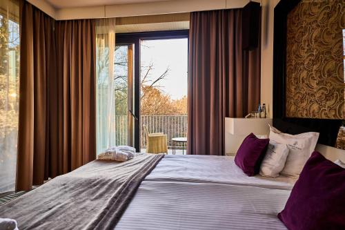 a bedroom with a large bed and a large window at Platinum Palace Boutique Hotel & SPA in Wrocław