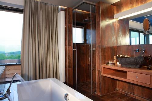 a bathroom with a bath tub and a shower at The Seven Hotel in Esch-sur-Alzette