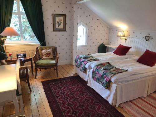 a bedroom with a bed and a table and a chair at Hotell Floras Trädgård in Öregrund