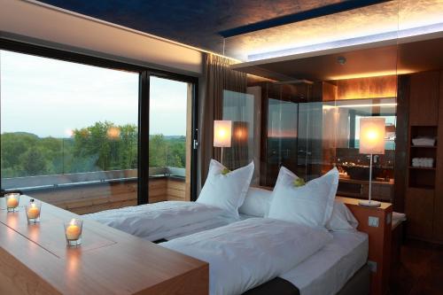 a bedroom with two beds and a large window at The Seven Hotel in Esch-sur-Alzette