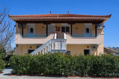 a house with a staircase in front of it at Agali Beach Apartments Seaside Stay in Chios in Mármaron