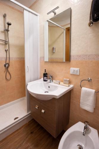 ein Badezimmer mit Waschbecken, Toilette und Dusche in der Unterkunft Chalet Lawà in Torre Caprara
