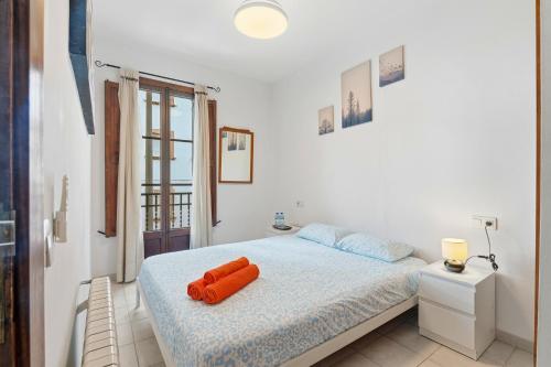 a bedroom with a bed with a red object on it at Rustica, Centrica & Agradable in Palma de Mallorca
