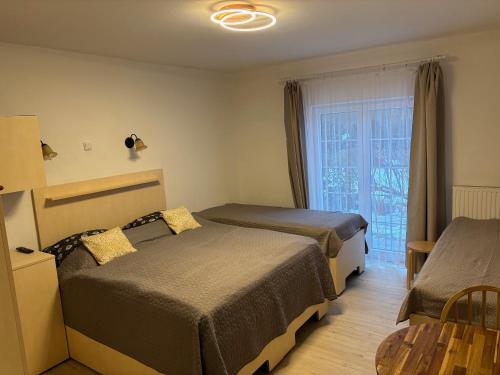 a hotel room with two beds and a window at Ubytování U draka in Třeboň