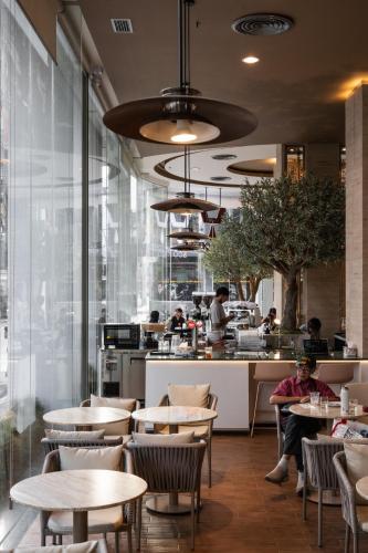 a restaurant with tables and people in a kitchen at Golden Crown Grand Hotel in Hat Yai