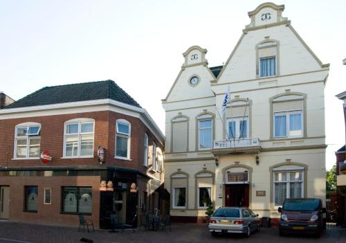 a group of buildings with cars parked in front of them at Pension Delfzijl in Delfzijl
