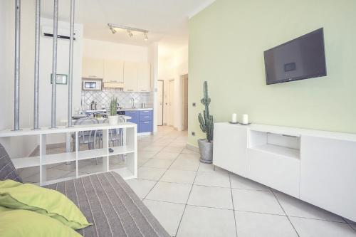 a living room with a couch and a tv on a wall at Excelsior in Piombino