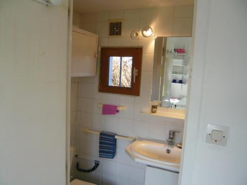 un piccolo bagno con lavandino e specchio di Châtaigne a Plouézec