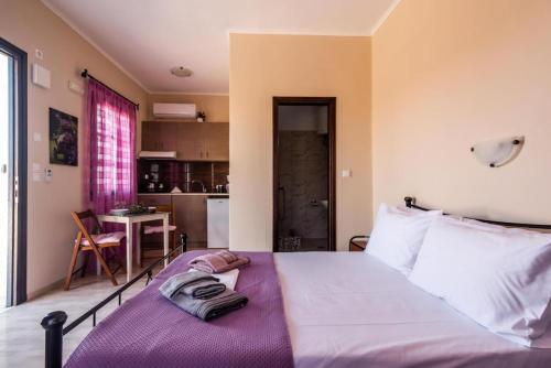 a bedroom with a large bed and a kitchen at Firiki Studios in Zefiría