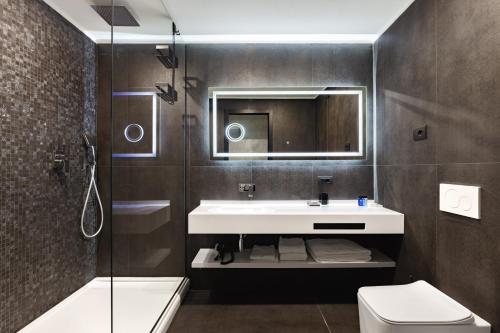 a bathroom with a sink and a mirror and a toilet at Dream Suite Trevi in Rome