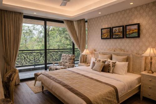 a bedroom with a large bed and a large window at Luxury Suites by Eden Wellness and Hospitality in Dehradun