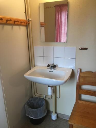 a bathroom with a sink and a mirror at Sunne Hembygdsgård B&B in Sunne